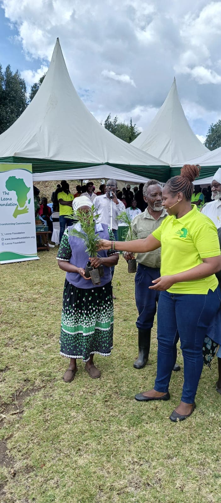 A Leona Foundation staff member handing a seedling to a community member